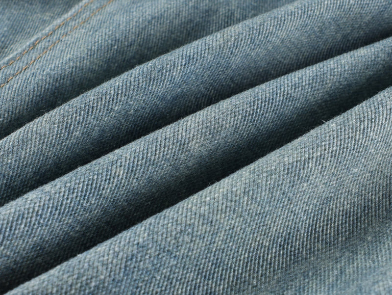 Close-up of blue denim fabric with heavy folds and textured weave