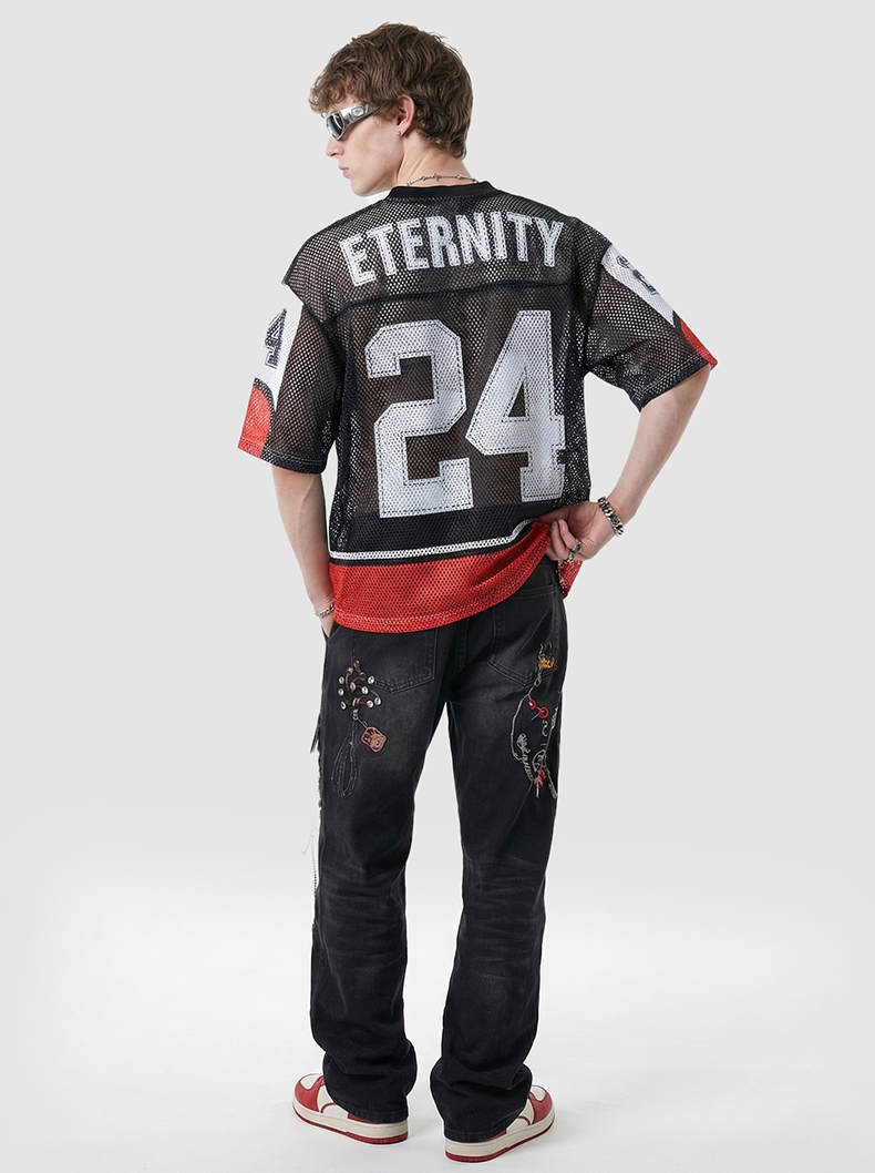 Back view of a model wearing a black mesh jersey T-shirt with ETERNITY 24 print, red hem, and streetwear styling