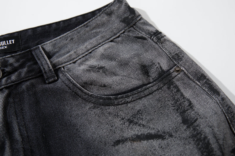 Close-up of the front waist and pocket on dark washed jeans with smoky gray texture