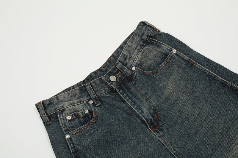 Close-up of front waistband, button closure, and coin pocket on faded blue jeans