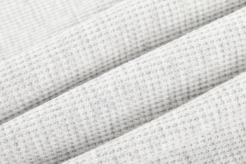 Close-up of white waffle-knit fabric texture on the T-shirt body