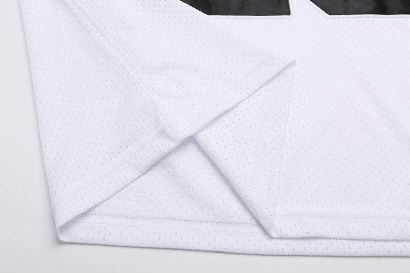 Close-up of a white mesh varsity football jersey T-shirt with textured fabric and stitched hem edges