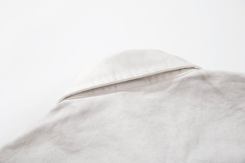 Close-up of a light gray short sleeve shirt collar and shoulder with a clean minimalist fabric texture