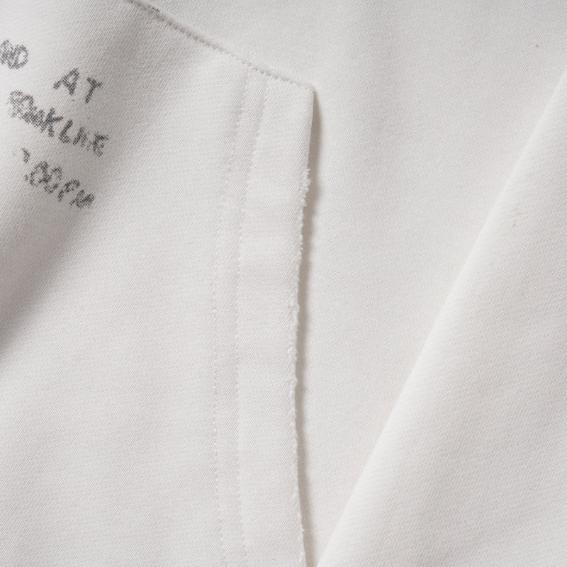Close-up of hoodie kangaroo pocket and printed text near the hem