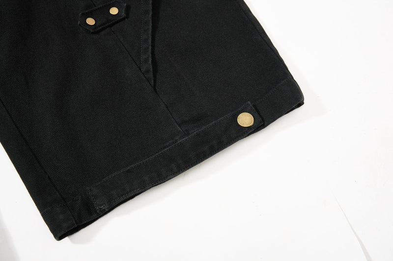 Close-up of black pant hem with gold snap button at the cuff