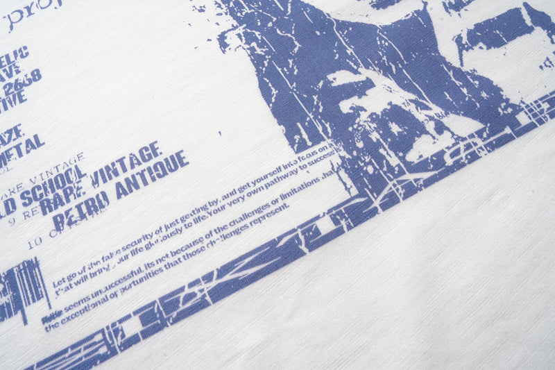 Close-up of blue vintage-style text and portrait print on the tee front