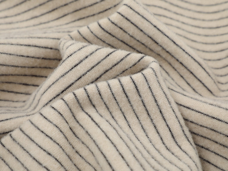 Close-up of beige striped knit fabric with soft folded texture