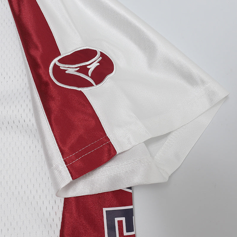 White performance jersey with burgundy side panels and embroidered logo on the sleeve, shown in close-up fold detail