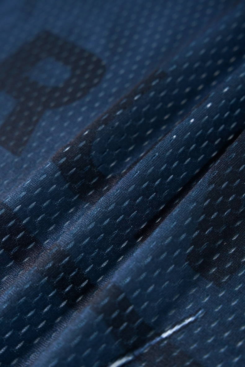 Close-up of navy mesh jersey fabric with dotted texture, showing the breathable athletic material of a streetwear run tee