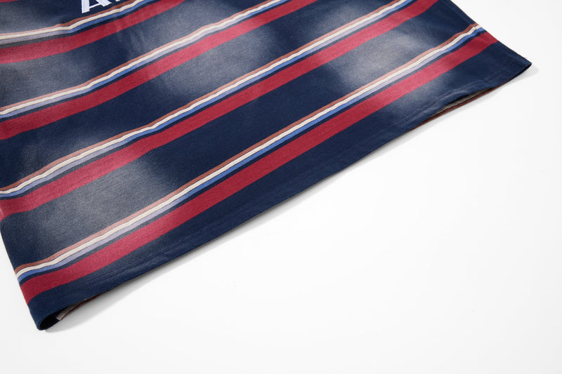Close-up of striped shirt hem with navy, red, blue, and cream horizontal bands