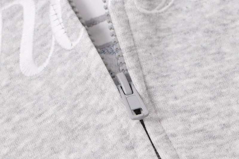 Close-up of light gray zipper and front seam on zip hoodie