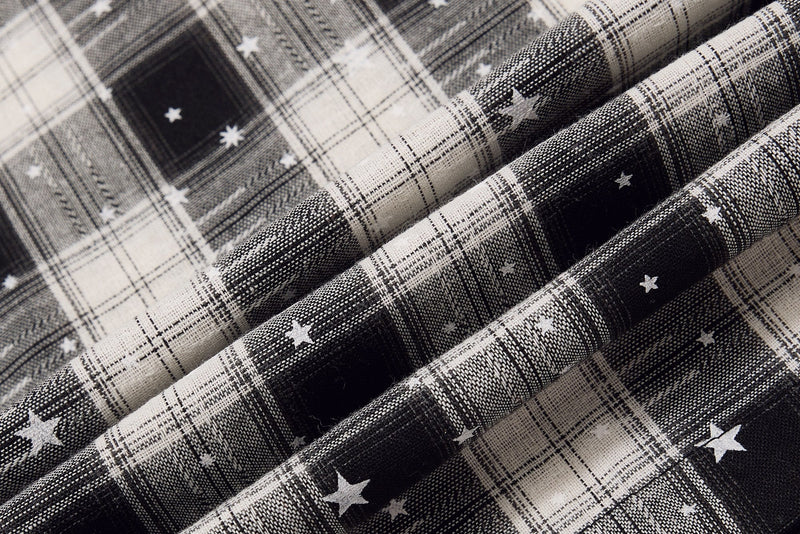 Close-up of folded plaid fabric with black and white star print