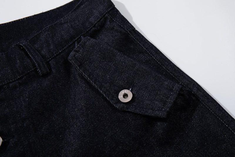 Close-up of the back side pocket and waist detail on dark indigo denim pants