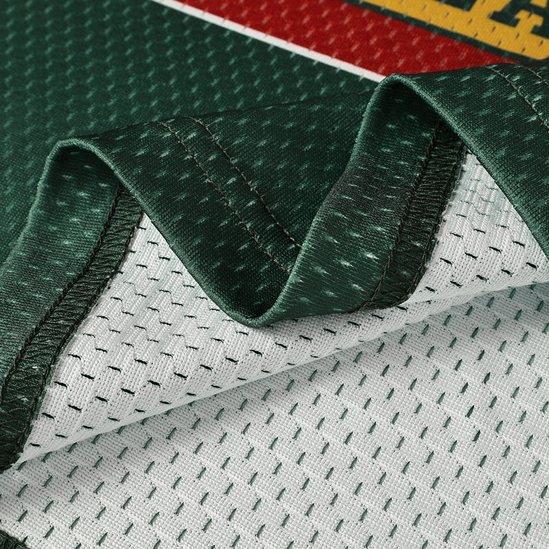 Close-up of a green football jersey mesh with white perforated fabric and stitched sleeve trim