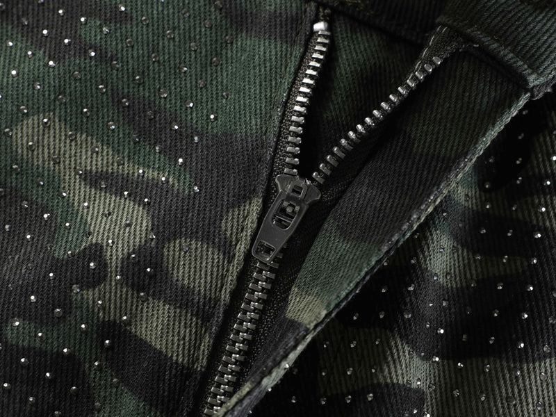 Close-up of camouflage denim with rhinestone embellishments and zipper detail