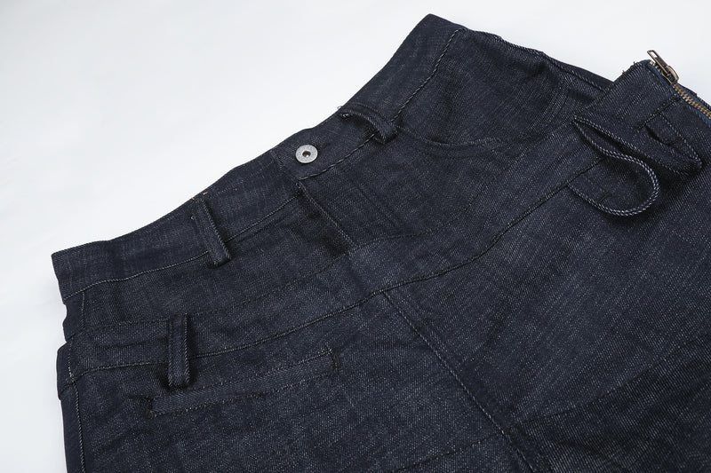 Angled close-up of dark denim waist with snap button and side zipper detail