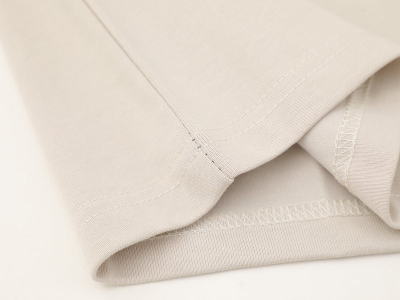 Close-up of cream tee hem and side seam stitching