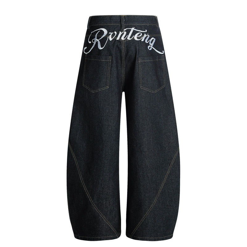 Black denim jeans back view with white script embroidery across the waistband