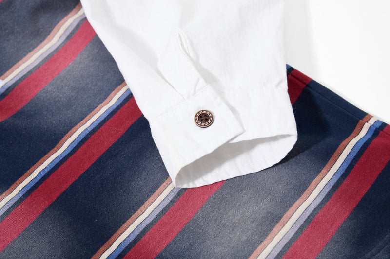 Close-up of white sleeve cuff with button on striped rugby polo shirt