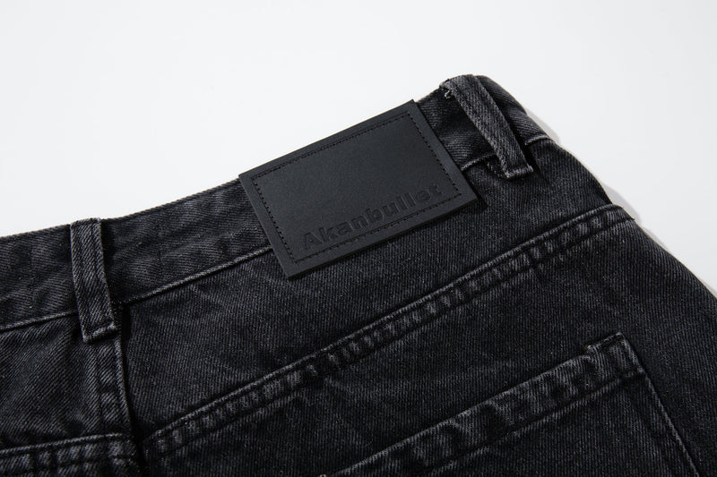 Close-up of the back waistband and branded patch on black denim jeans