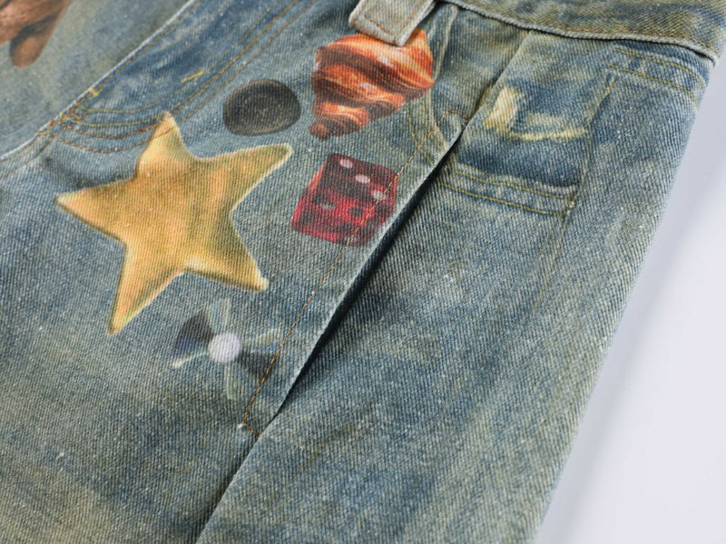 Close-up of star, dice, and shell graphics on blue denim jeans
