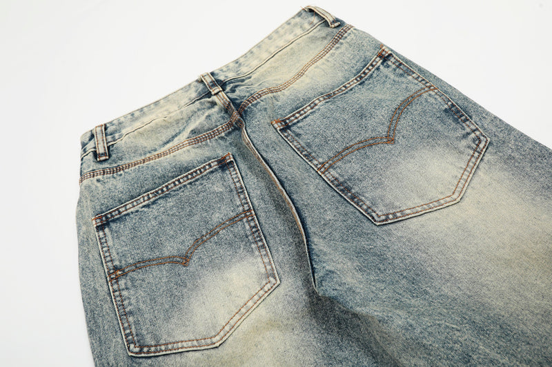 Close-up of light wash jeans back pockets and waistband with faded vintage wash