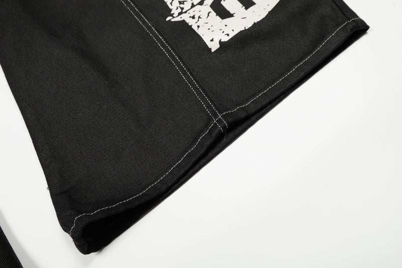 Close-up of the hem of black wide leg denim pants with visible contrast stitching