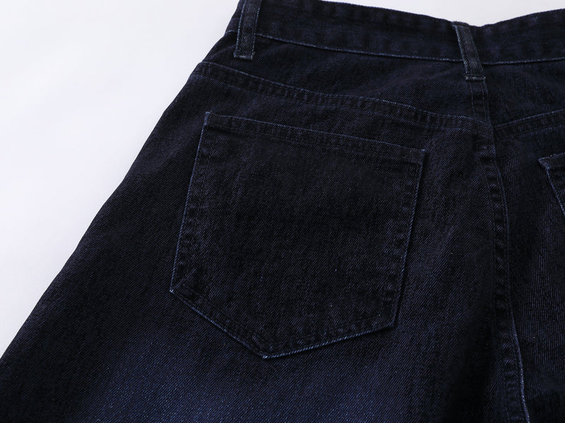 Close-up of the back pocket on faded indigo denim pants