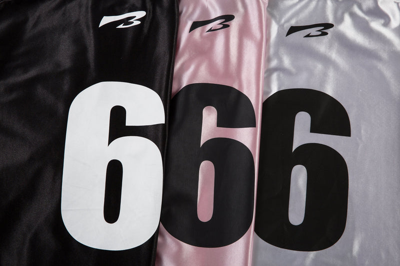 Side-by-side front upper views of black, pink, and white jerseys with logo and 6