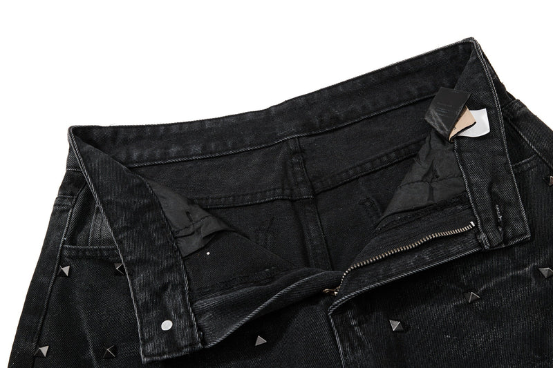 Waistband interior view of black studded jeans with zipper and care labels