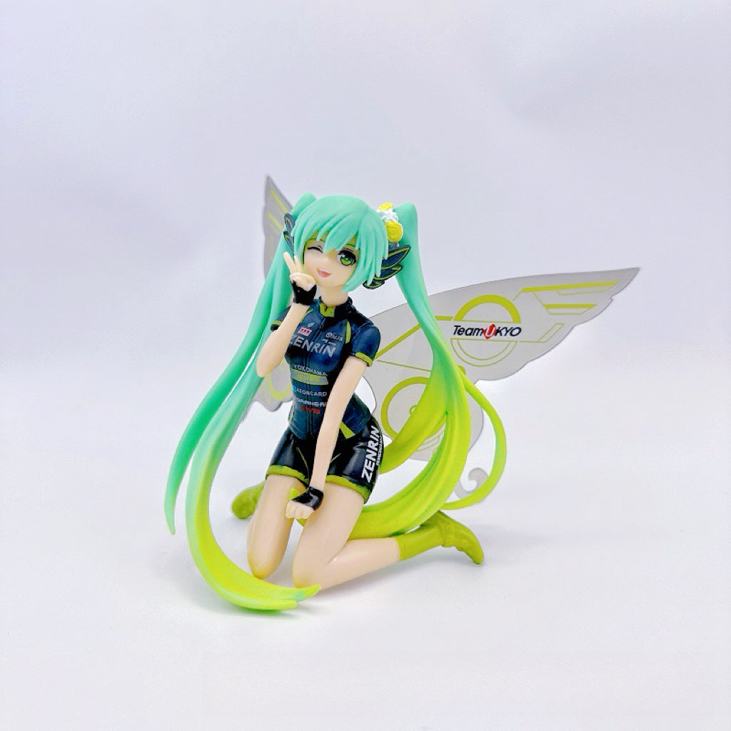 The Racing Butterfly Hatsune Miku 12cm PVC Figure by Hatsune Miku showcases her kneeling with turquoise twin tails, a black outfit with colorful accents, green boots, and yellow-silver Racing Butterfly wings featuring &quot;TeamUKYO&quot; and &quot;ZENRIN&quot; logos.