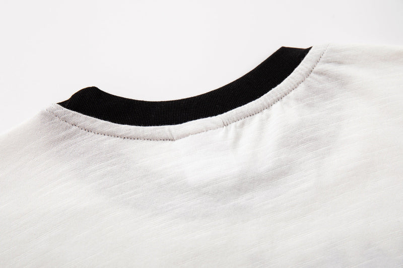 Close-up of a white ringer T-shirt collar with black ribbed trim and visible stitching detail