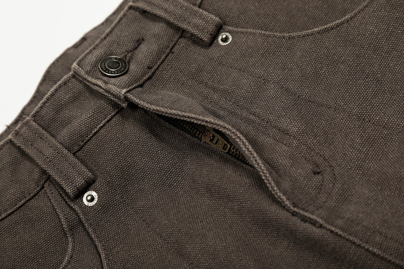 Close-up of brown pants front waistband with zipper partially visible