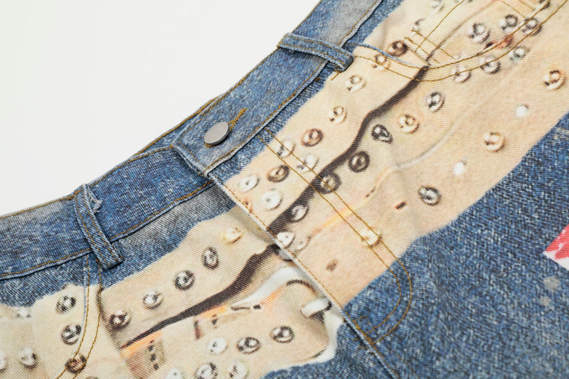 Close-up of denim waistband showing studded print, belt loop, and front button detail