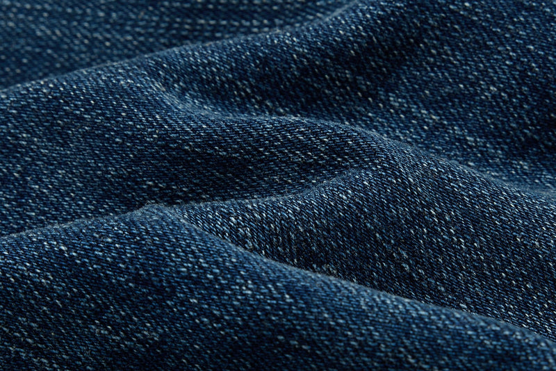 Close-up of blue denim fabric folds and textured weave