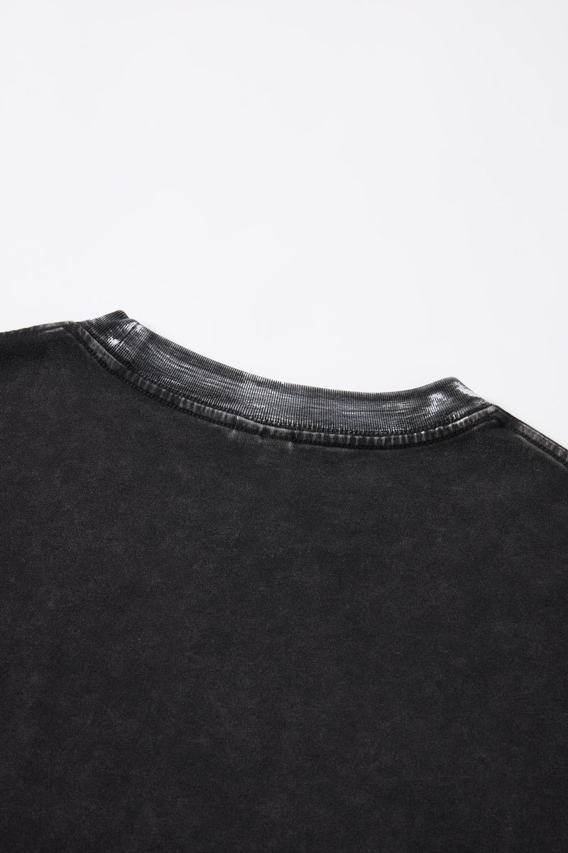 Close-up of a washed black streetwear T-shirt collar with faded seam detailing and vintage distressed finish