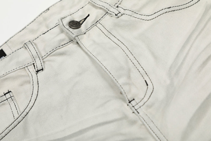 Close-up of front pocket and waistband stitching on light gray jeans