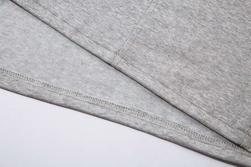 Close-up of the light gray hem with visible stitching and overlocked edge