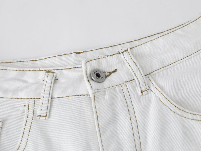 Close-up of the front waistband with button, belt loops and topstitching on white denim shorts