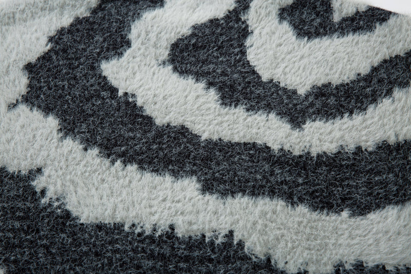 Close-up of black and white zebra stripe pattern on the fluffy knit sweater