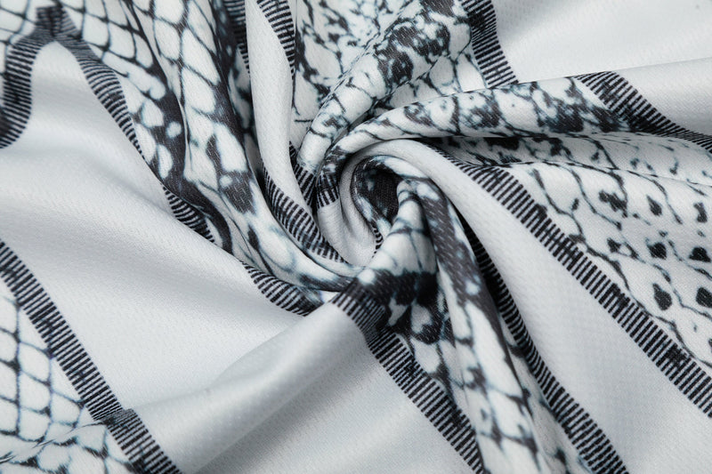 Close-up of white jersey fabric with black snakeskin print and striped details in a gothic streetwear style