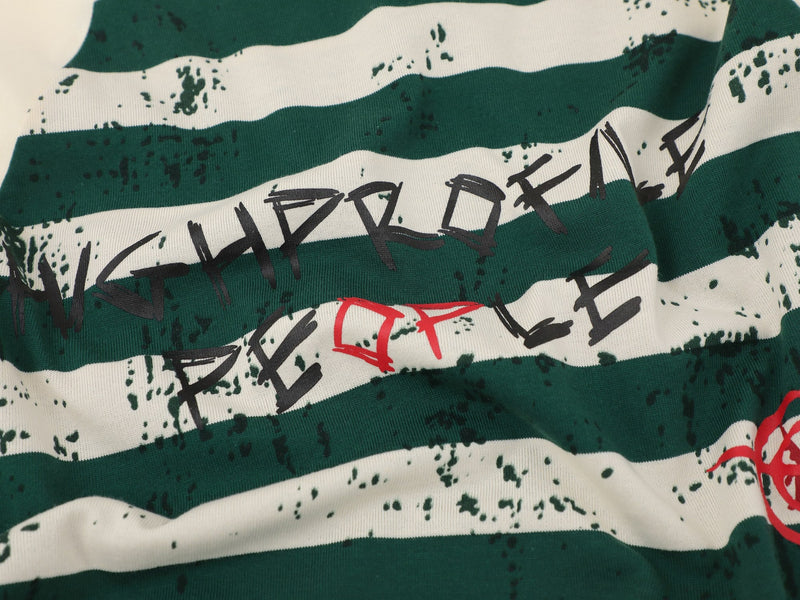 Close-up of cream tee front with dark green stripes and HIGH PROFILE PEOPLE text graphic