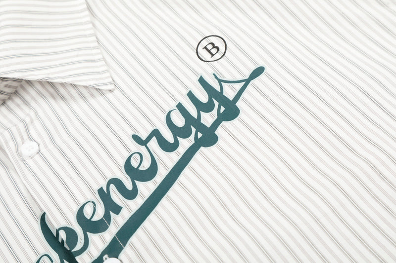 Close-up of front chest graphic and button on cream striped button-up shirt