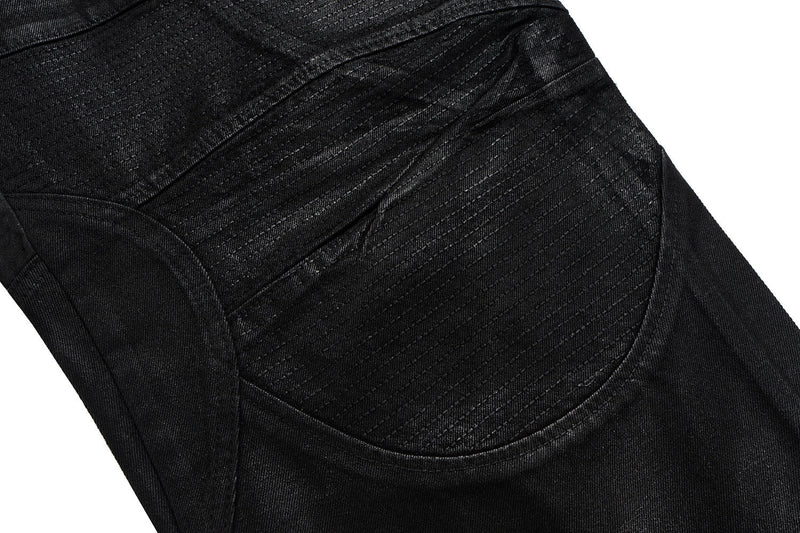 Close-up of black pants knee panel with curved stitching