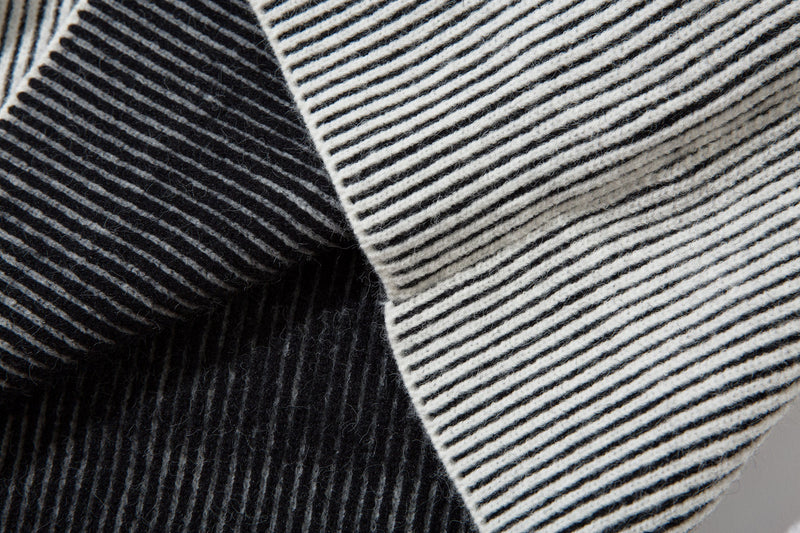 Close-up of black and white striped ribbed knit sleeve crossover