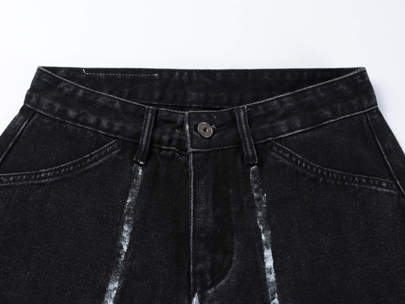 Close-up of black jeans waistband with button closure, belt loops and faded wash details