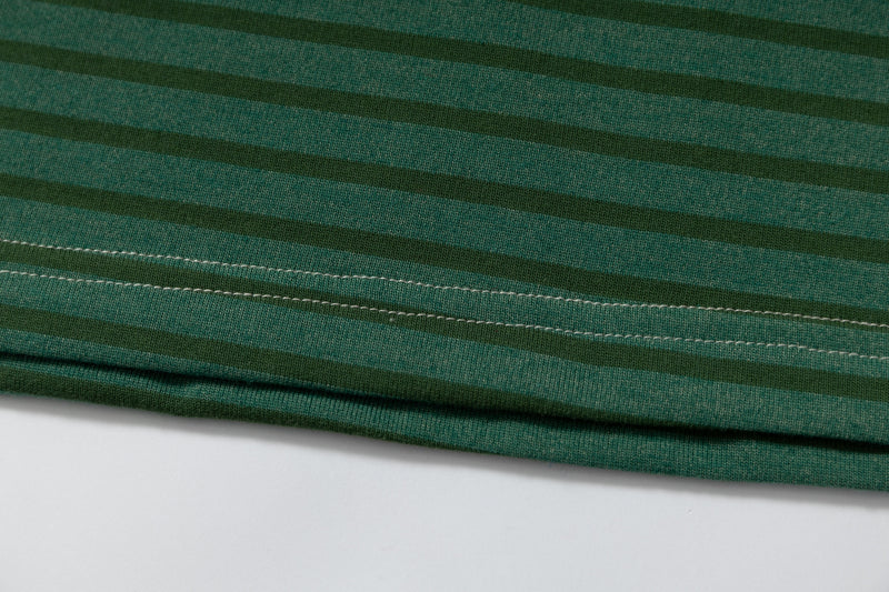 Close-up of green striped cotton fabric with stitched hem detail