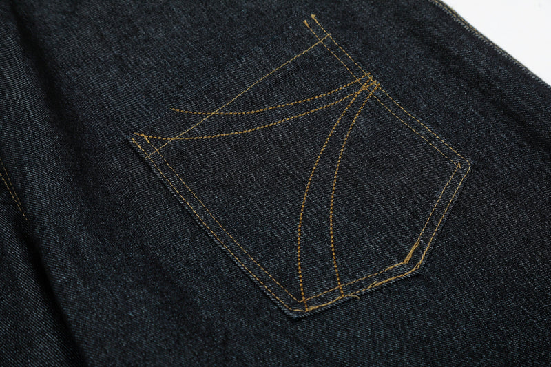 Close-up of back pocket on black denim jeans with curved arc stitching