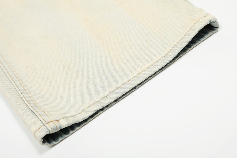 Hem close-up of cream wide-leg jeans with stitched cuff detail