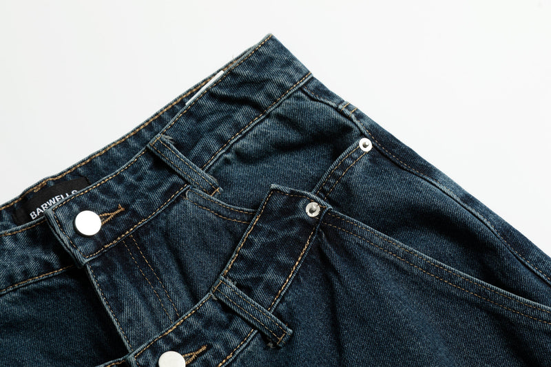 Close-up of front waist and pocket seams on dark blue jeans with double-button detail